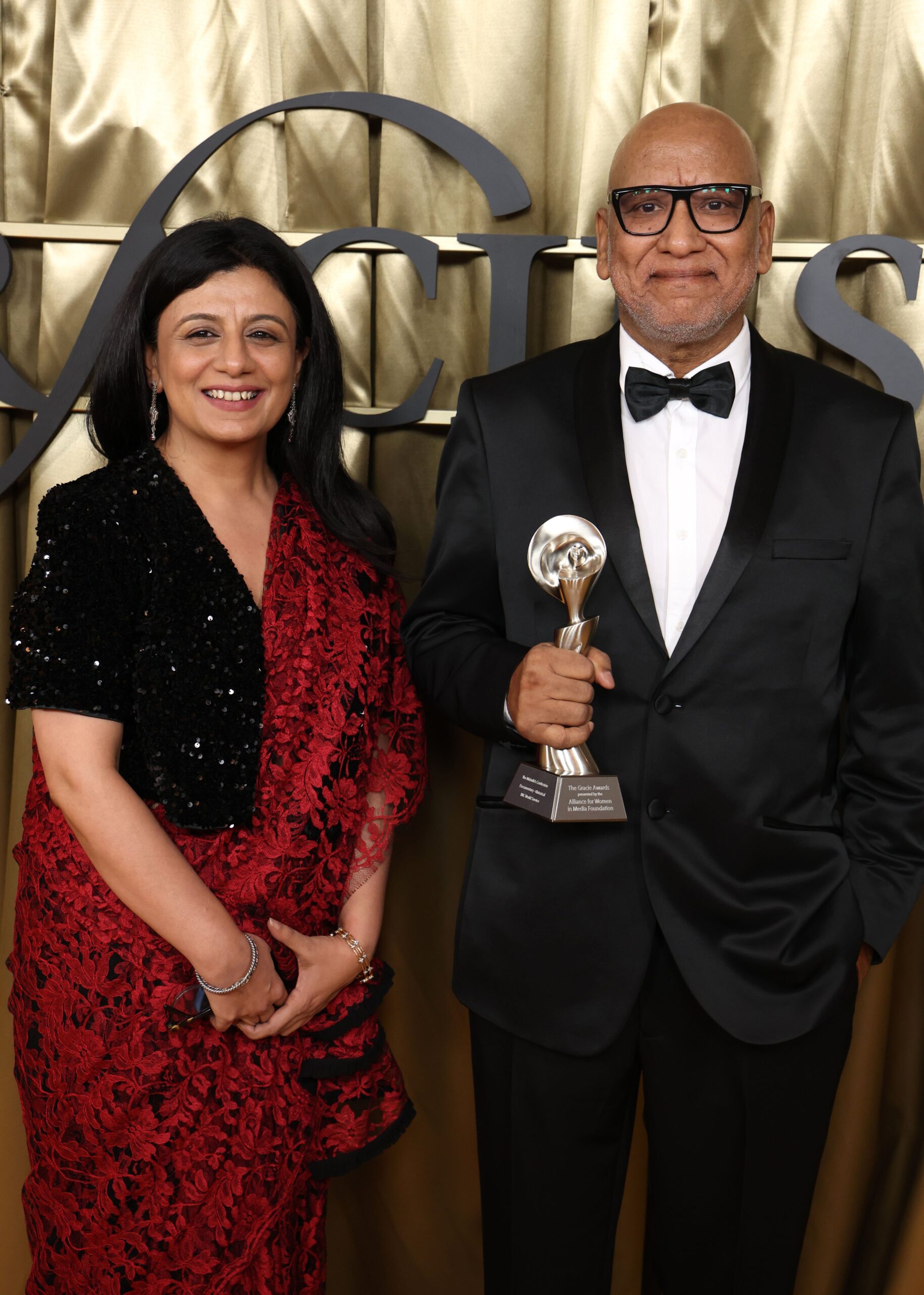 Photograph of Anubha-Bhonsle, Amitabh Parashar at Gracies Annual Awards for The Midwife's Confession, a film by BBC World Service. Anubha is wearing a red glittering sari